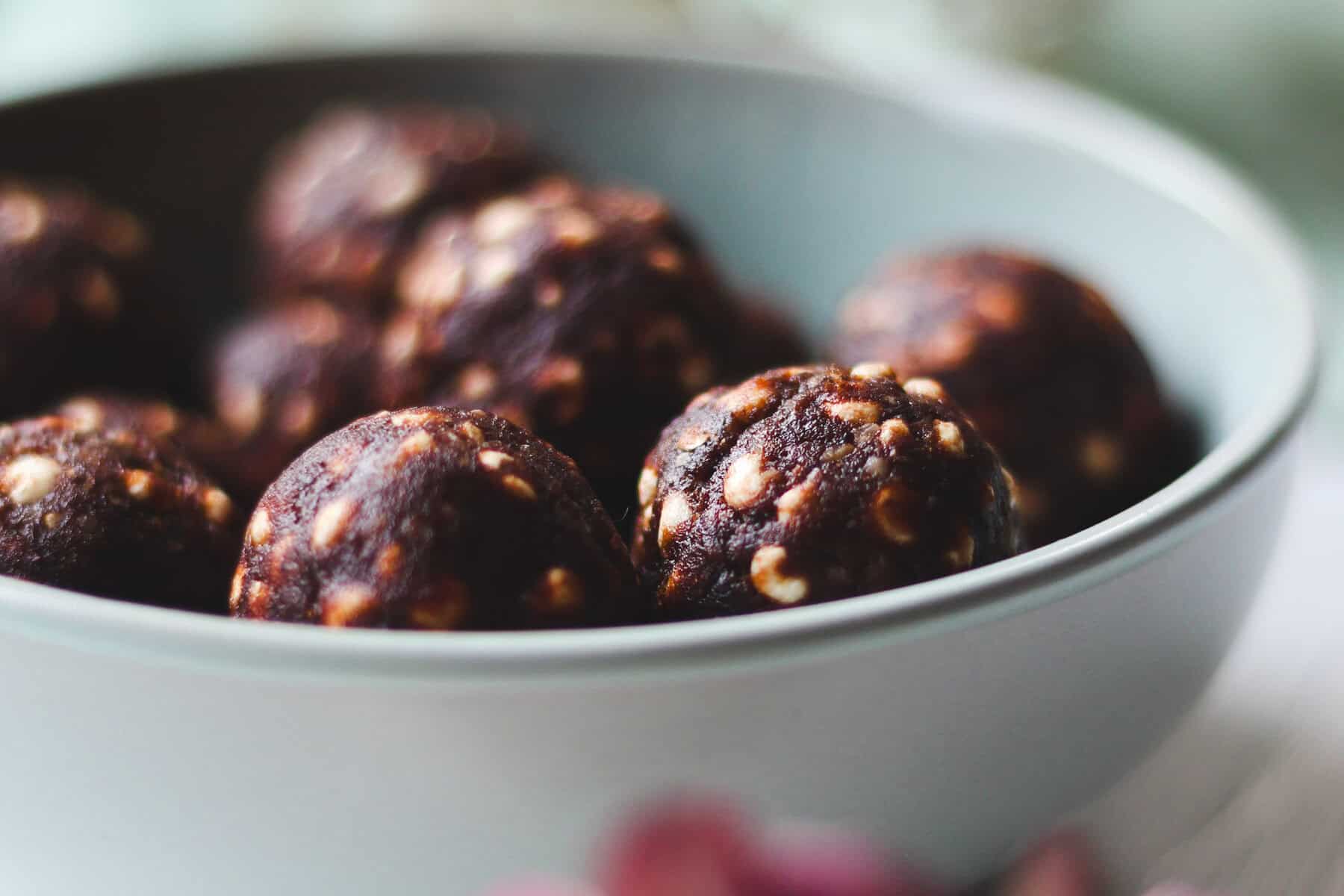 Saftige vegan Schoko-Haselnuss Kugeln in weißer Schüssel.