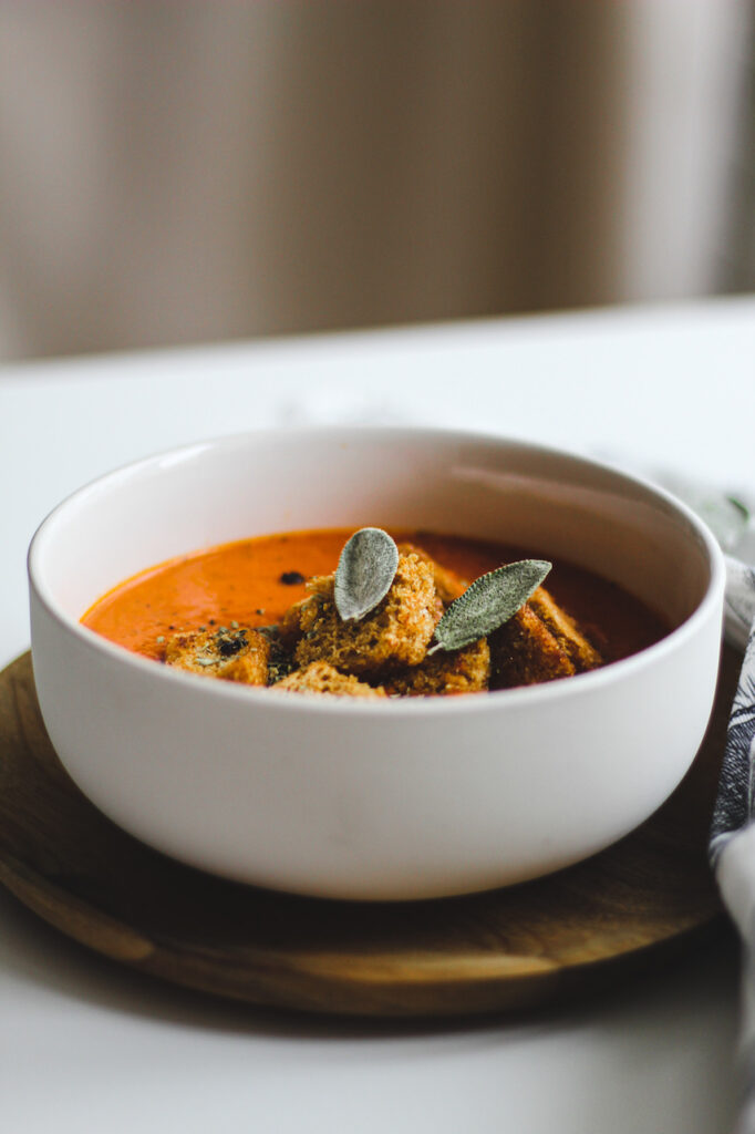 vegane tomatencremesuppe mit Croûtons in einem Suppenteller