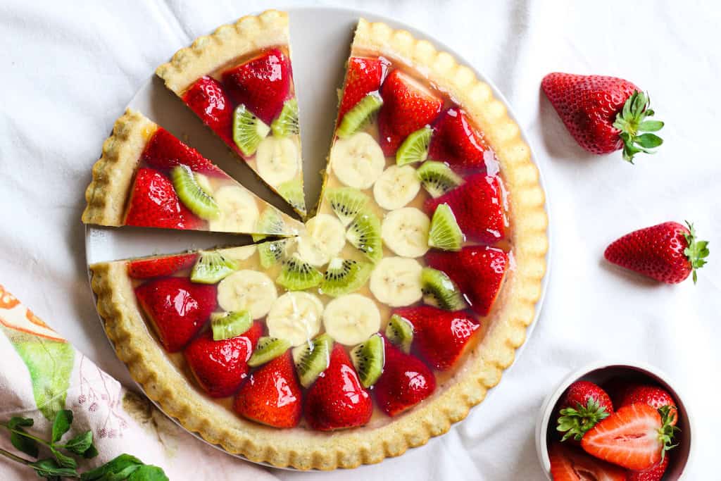Frischer Obstkuchen mit Erdbeeren, Bananen und Kiwi aus biologischem Anbau bei Pflanzlich Gut.