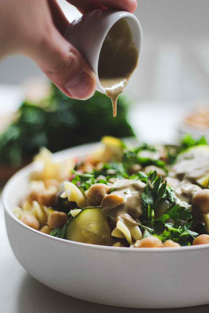 Über die Pasta mit buntem Gemüse wird Tahin darüber gegossen