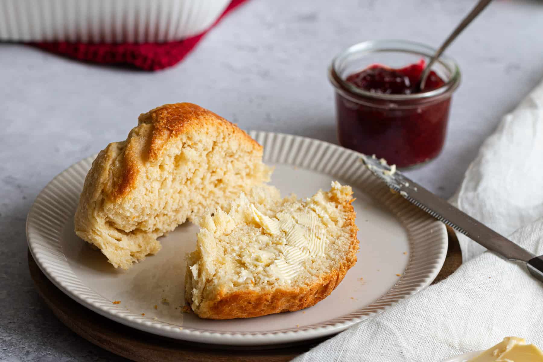 vegane Milchbrötchen auf einem Teller mit Erdbeermarmelade und Butter