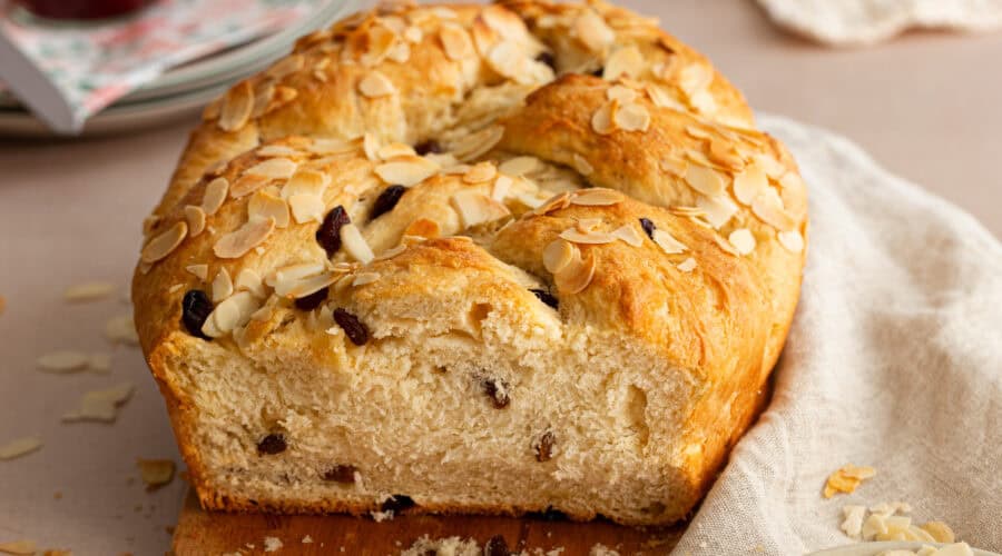 Veganer Striezel mit Rosinen, frisch gebacken und mit Mandeln bestreut.