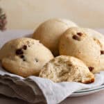 vegane Rosinenbrötchen auf einem Teller mit einem Geschirrtuch