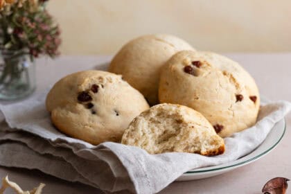vegane Rosinenbrötchen auf einem Teller mit einem Geschirrtuch