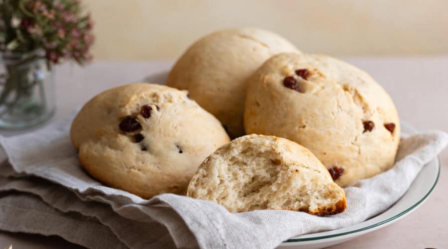 vegane Rosinenbrötchen auf einem Teller mit einem Geschirrtuch