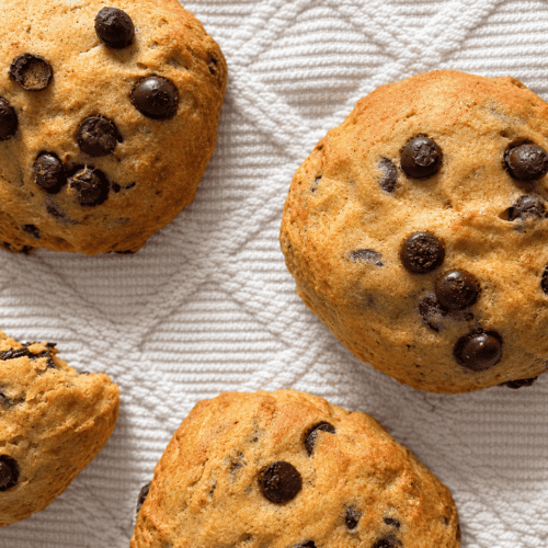 Vegane Kürbis-Schokoladenkekse auf weißem Tuch, frisch gebacken.