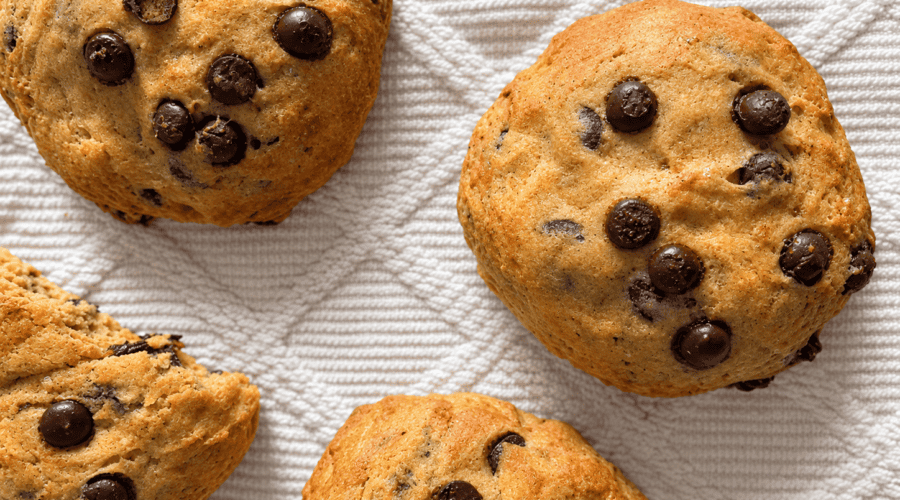 Vegane Kürbis-Schokoladenkekse auf weißem Tuch, frisch gebacken.