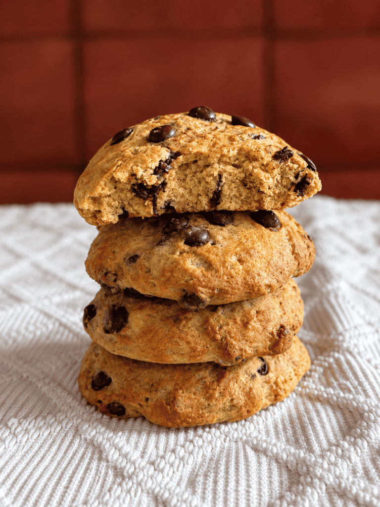 Vegane Kürbis-Schokoladenkekse auf weißem Tuch, frisch gebacken.